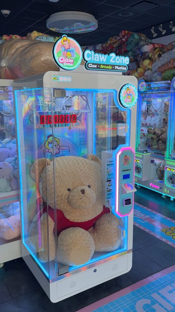 A giant teddy bear waiting inside a Claw Zone prize machine